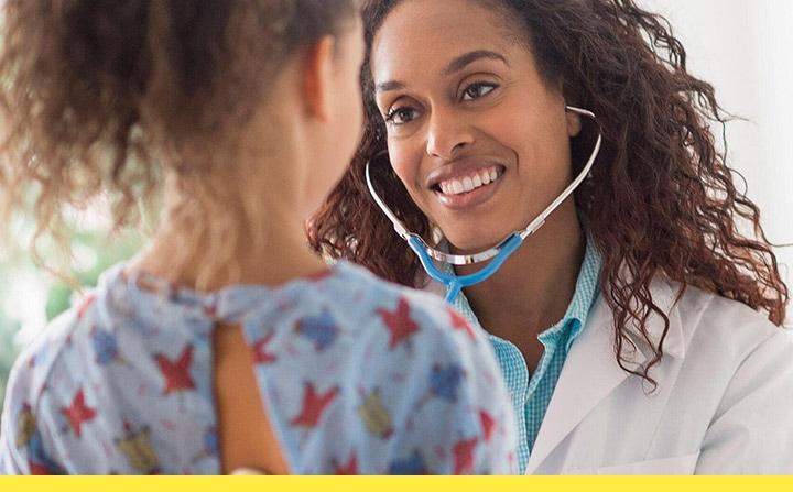 A physician with a stethoscope examining a young girl